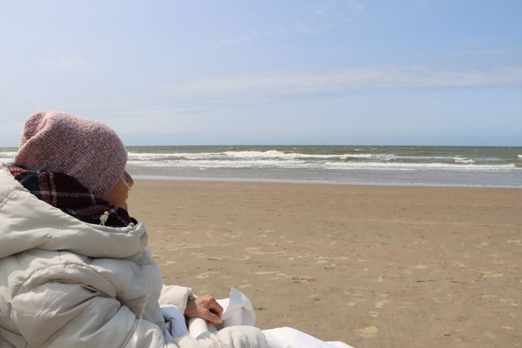 Kranke Frau blickt aufs Meer